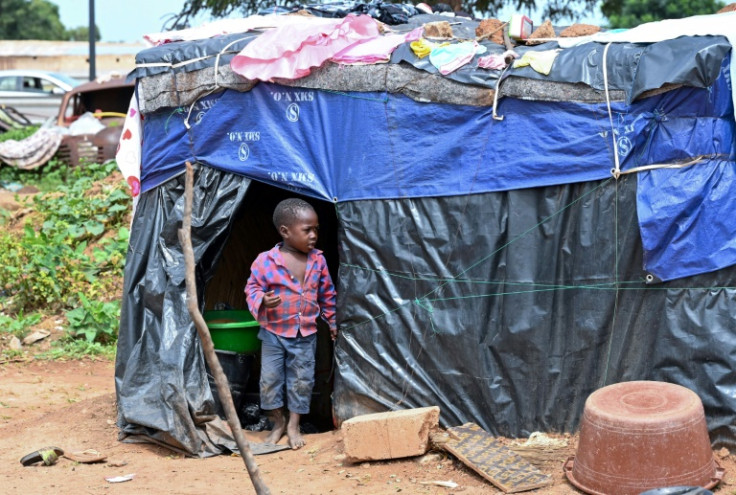 Un niño desplazado que huyó de los ataques de los yihadistas en el norte y el este de Burkina Faso se encuentra junto a una tienda de campaña improvisada en Gampela, cerca de Uagadugú, el 6 de octubre de 2022.