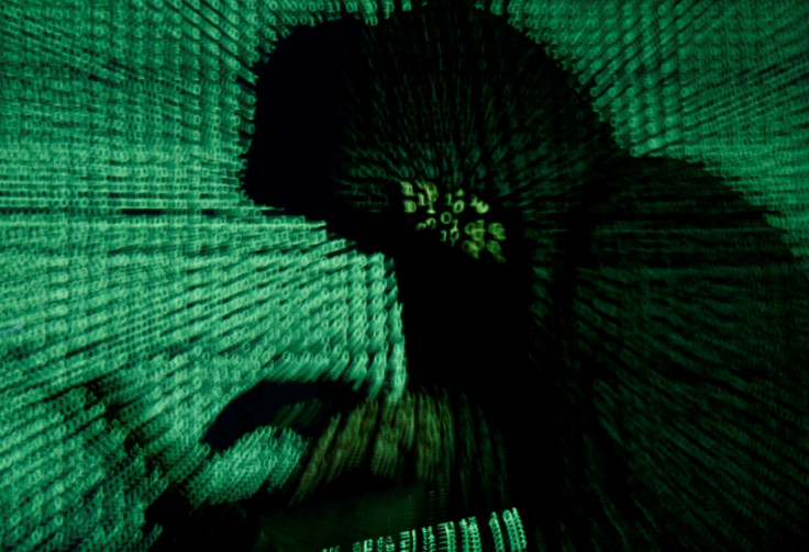 El hombre sostiene una computadora portátil mientras se proyecta un código cibernético sobre él en esta imagen ilustrativa