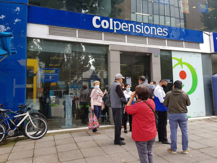 La gente espera frente a una oficina del fondo de pensiones estatal Colpensiones en Bogotá.