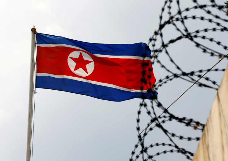 Una bandera de Corea del Norte ondea junto a una concertina en la embajada de Corea del Norte en Kuala Lumpur.