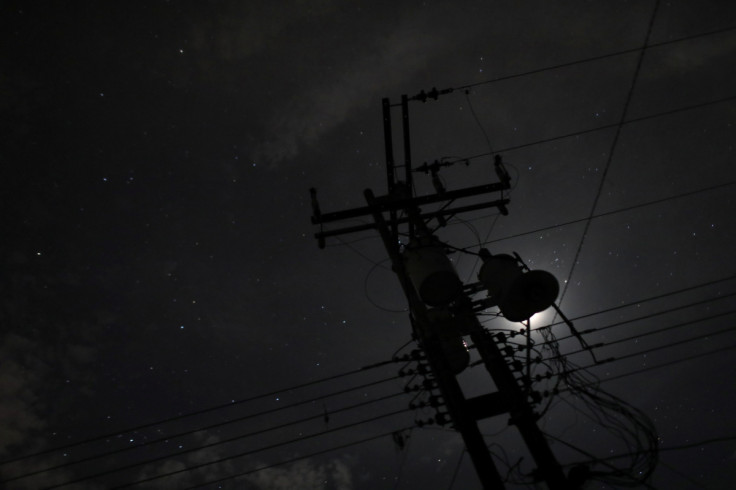 Una torre de electricidad se ve contra la luz de la luna durante un apagón en Guigue