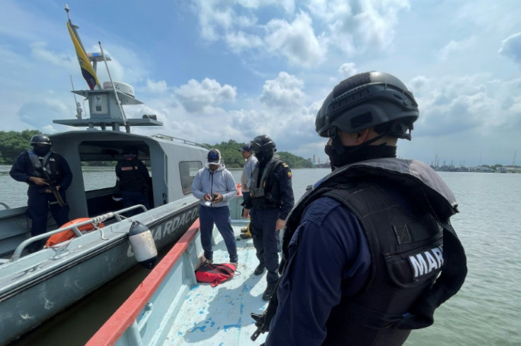 La policía naval ecuatoriana revisa los documentos de la tripulación de una pequeña embarcación interceptada cerca del puerto de Guayaquil el 11 de mayo de 2023