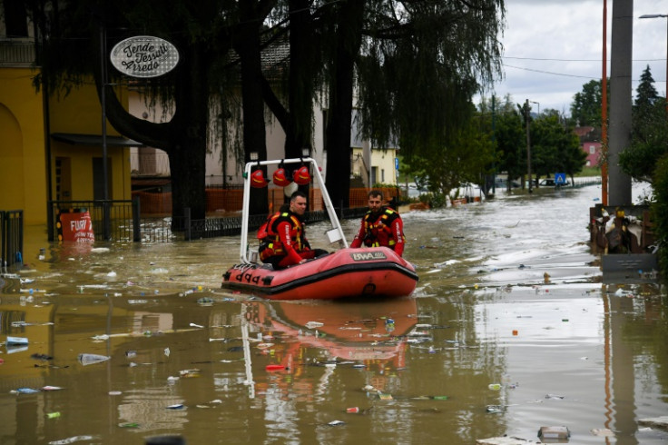 Bomberos voluntarios montan su bote a través de una calle inundada por el río Savio en el distrito Ponte Vecchio de Cesena, centro-este de Italia, el 17 de mayo de 2023.