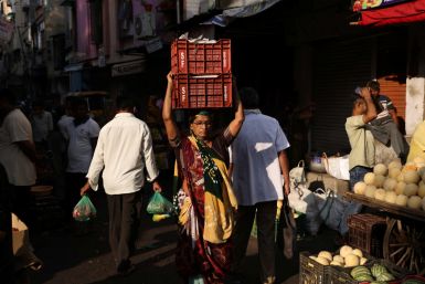 Mujer lleva cajas de verduras en la cabeza en un mercado de Ahmedabad