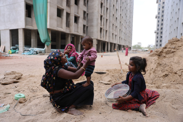 Heena Parmar juega con su hijo Vaibhav mientras su hija Sonal observa un sitio de construcción en Ahmedabad.