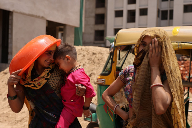Las mujeres se refugian del sol en un sitio de construcción en Ahmedabad