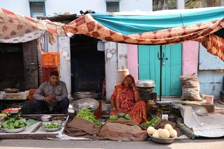 Kantaben Kishanbhai Parmar espera a los clientes en su puesto de verduras al borde de la carretera en Ahmedabad