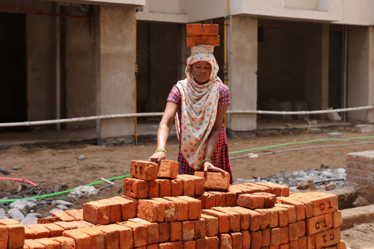 Una mujer carga ladrillos en un sitio de construcción en Ahmedabad.