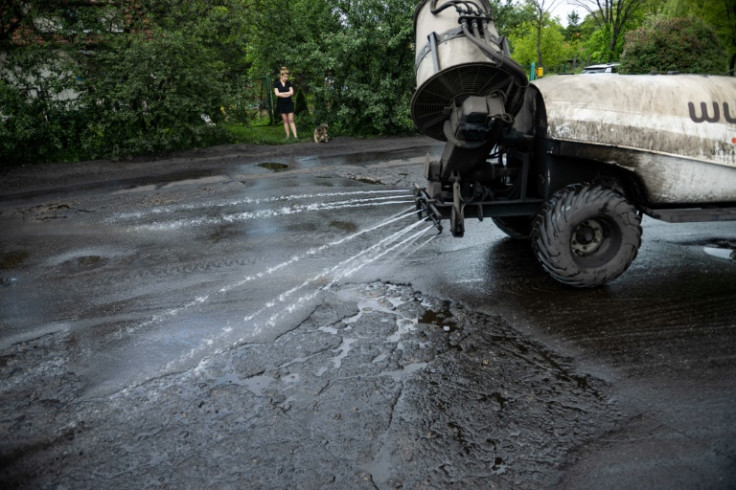 Un vehículo rocía agua para humedecer el polvo de carbón afuera de la casa de Iwona Wozniewska en Gdansk, Polonia.