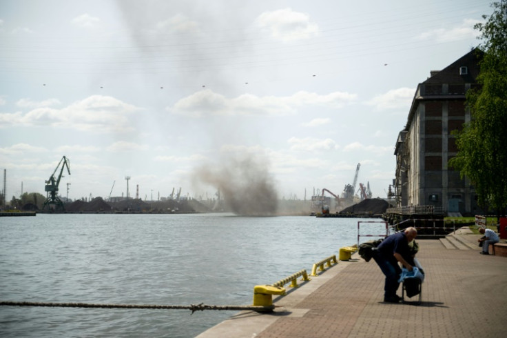 Un hombre empaca para irse mientras una gran nube de polvo de carbón se arremolina sobre el puerto de Gdansk, Polonia.