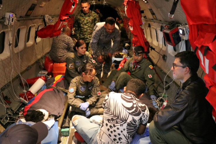 Esta fotografía del folleto tomada el 9 de junio de 2023 y publicada por la Fuerza Aérea Colombiana muestra a miembros del Ejército de Colombia revisando a uno de los cuatro niños indígenas que fueron encontrados con vida después de estar perdidos durante