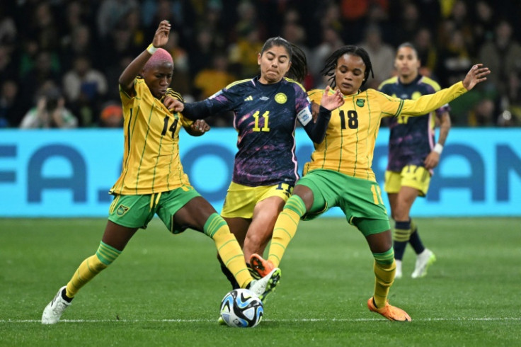 La delantera de Colombia Catalina Usme (C) lucha por el balón contra Jamaica