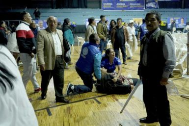 Una mujer es asistida tras ser herida por disparos durante el asesinato del candidato presidencial Fernando Villavicencio tras un mitin en Quito