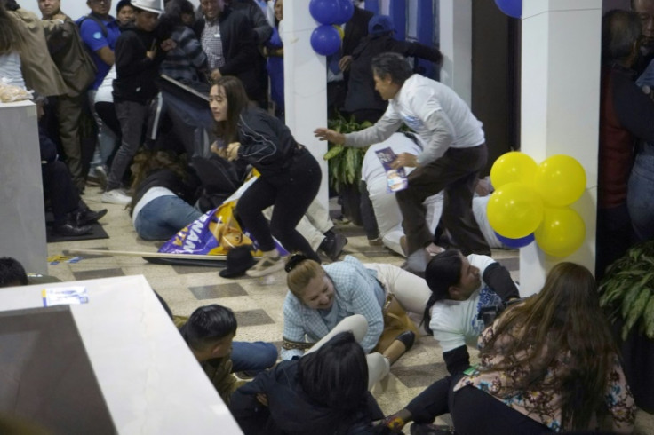 La gente se pone a cubierto después de los disparos al final de un mitin del candidato presidencial ecuatoriano Fernando Villavicencio en Quito.