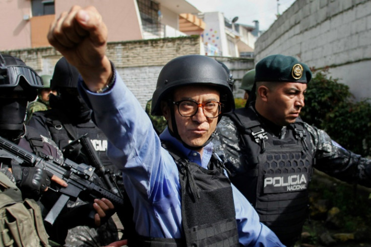 El candidato presidencial ecuatoriano, Christian Zurita, hace un gesto al salir bajo fuertes medidas de seguridad después de votar en un colegio electoral en Quito.