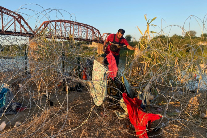 El venezolano Alejandro Urdaneta se abre paso entre una maraña de alambres de púas cerca de la localidad texana de Eagle Pass, uno de los cientos de migrantes que llegan en un solo día.